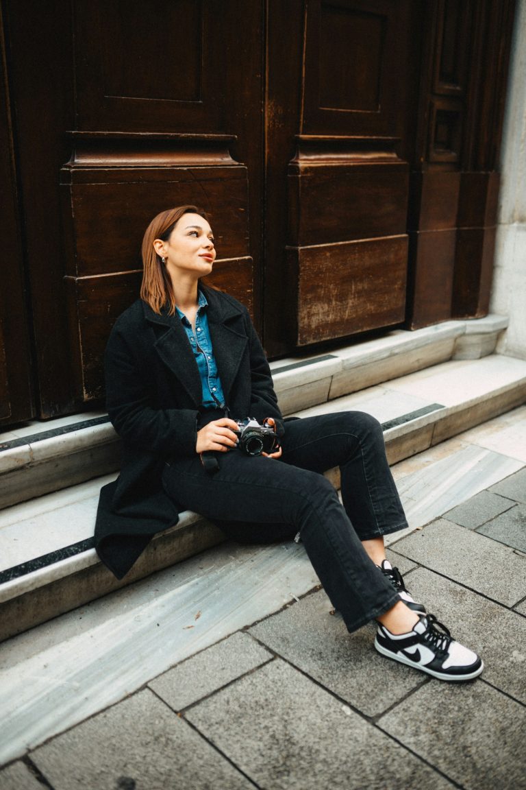 a woman sitting on a step with a camera