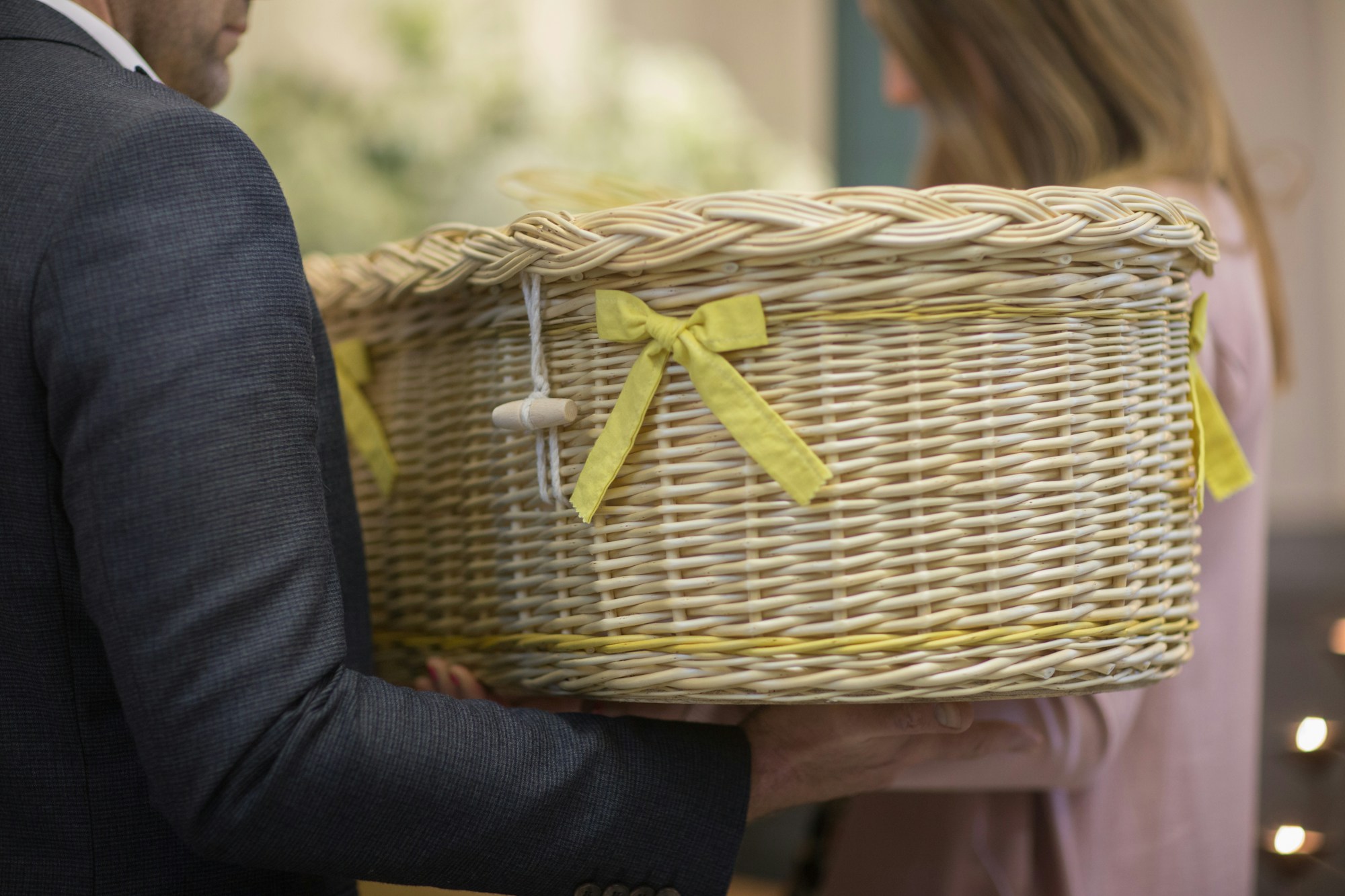 a man in a suit holding a wicker basket