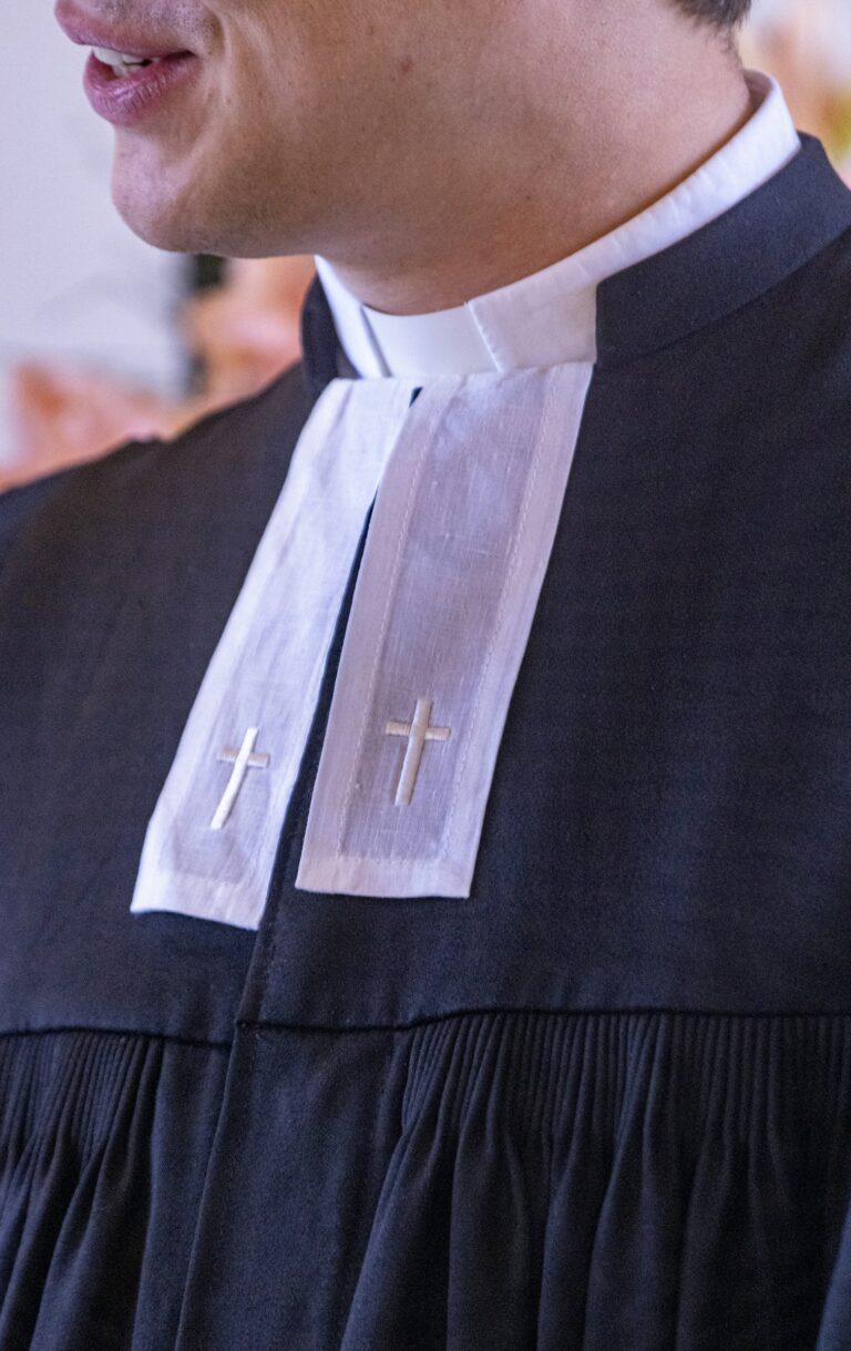 A close up of a person wearing a priest's robe